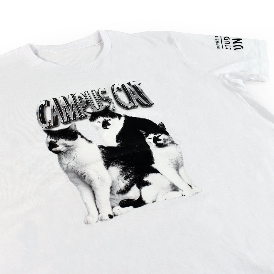 A white t-shirt with the words " Campus Cat" on the front and three pictures of a black and white cat printed on it, close-up on the design